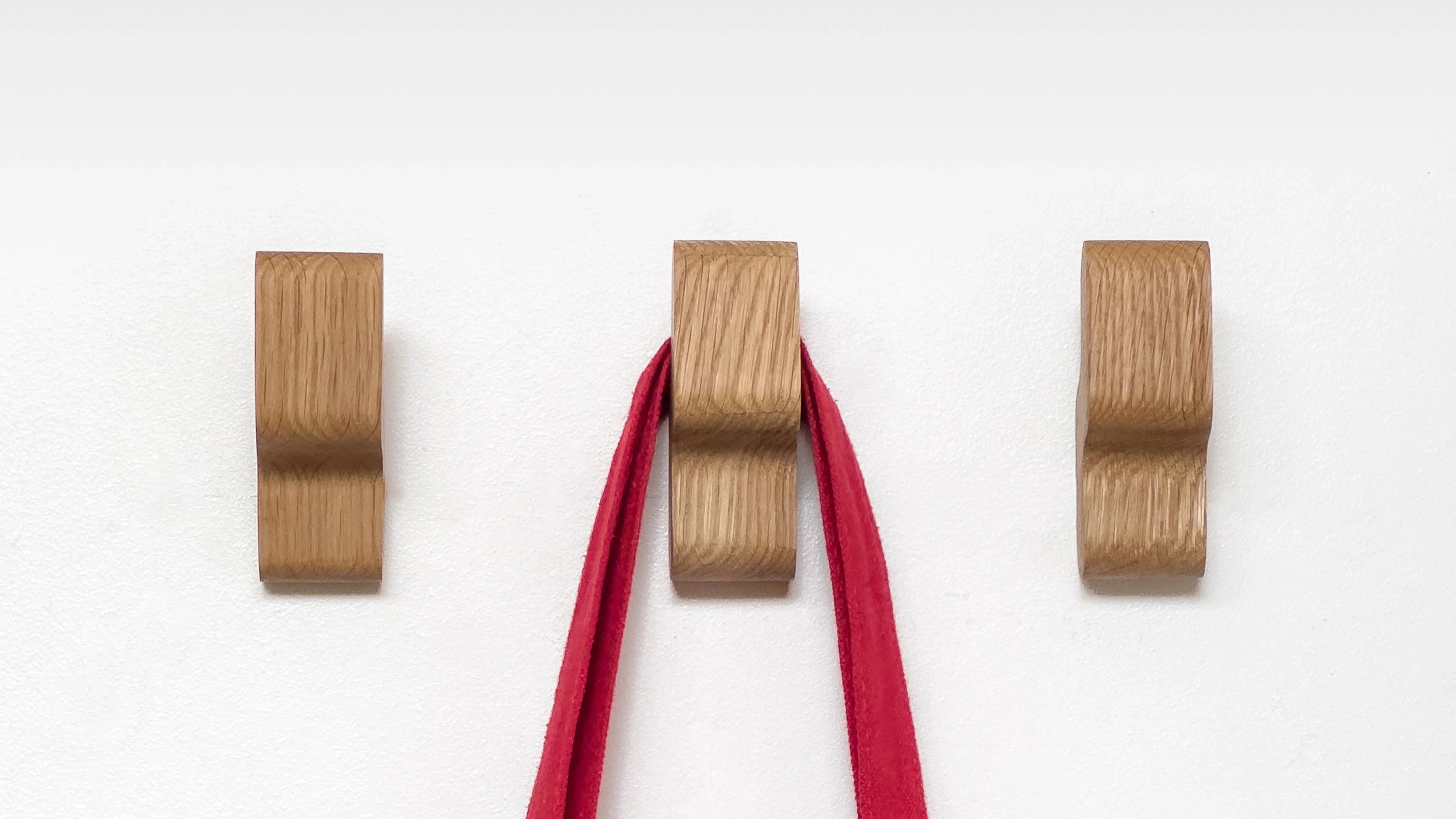 Crochets en bois de chêne avec lanières rouges, design épuré et écoresponsable